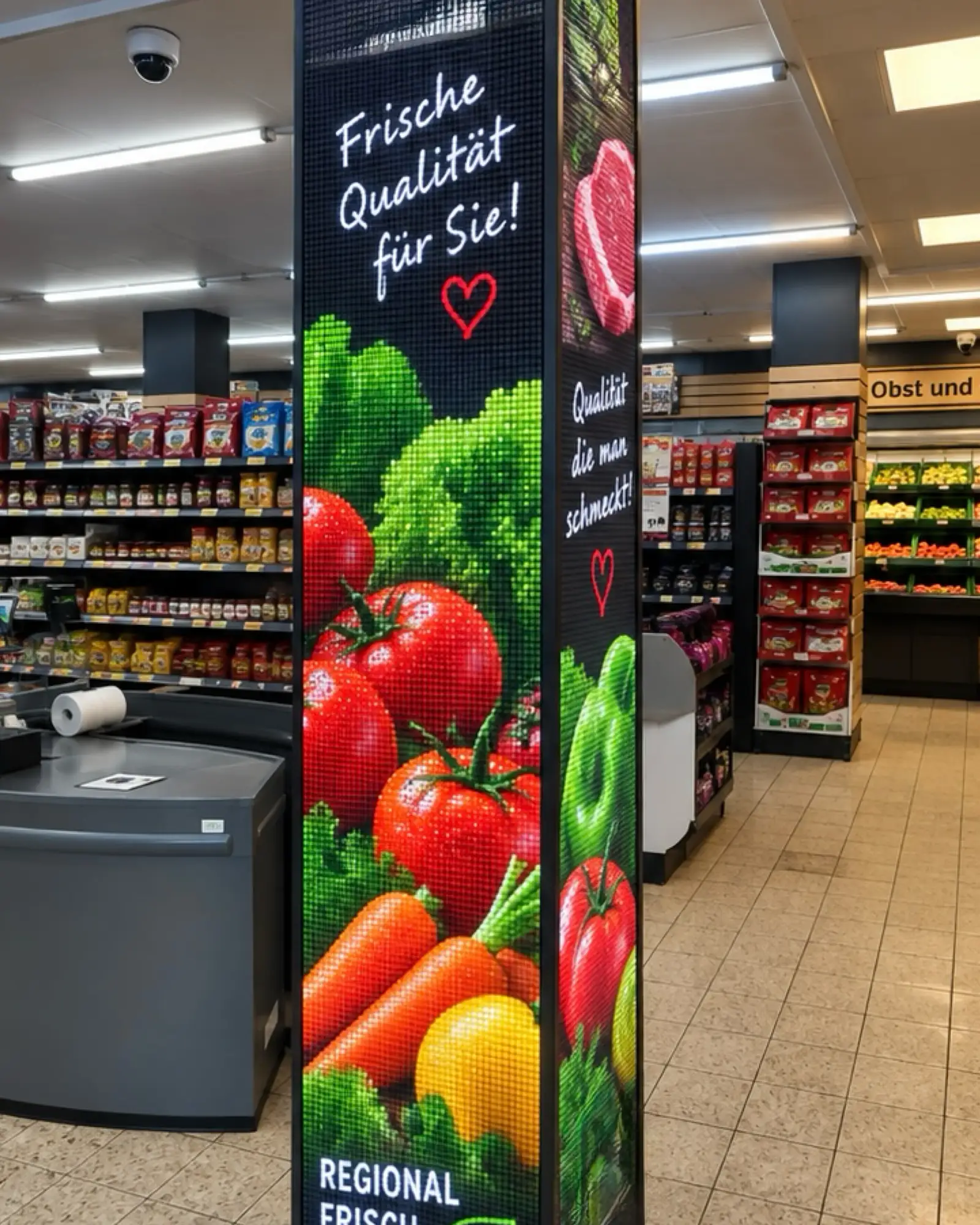 Visualisierung: LED-Säule im Supermarkt mit Tomaten, Karotten und dem Slogan „Frische Qualität für Sie!“, daneben die Kasse